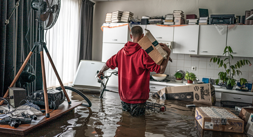 : Een inwoner van de stad Meerssen, gezien in zijn woonkamer in Nederland, is zijn spullen aan het inpakken nadat veel huizen zijn overstroomd door hevige regenval.